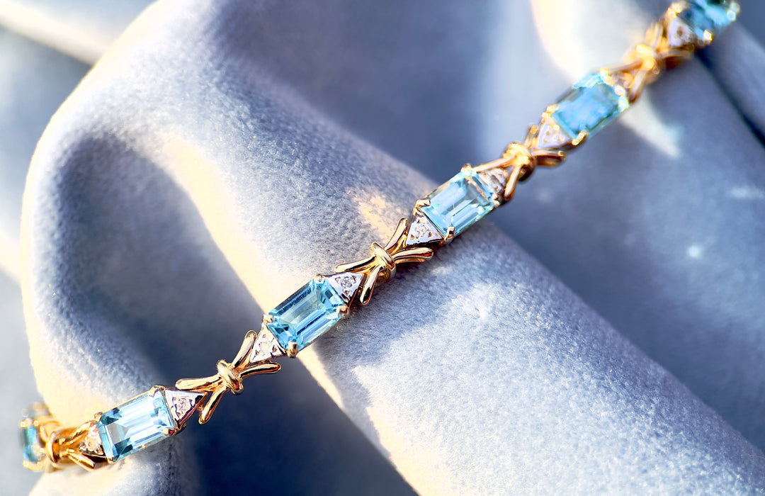 “Frost and Bows” Emerald Cut Blue Topaz with Diamond Accents in 14k Yellow Gold