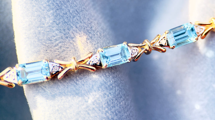 “Frost and Bows” Emerald Cut Blue Topaz with Diamond Accents in 14k Yellow Gold