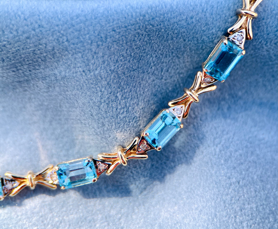 “Frost and Bows” Emerald Cut Blue Topaz with Diamond Accents in 14k Yellow Gold